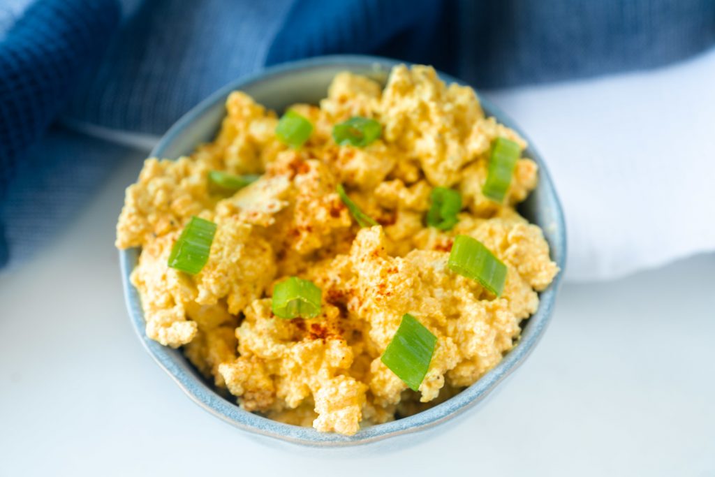 close up of a bowl of tofu egg salad with green onions