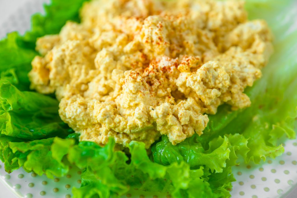 close up of vegan egg salad on a bed of lettuce