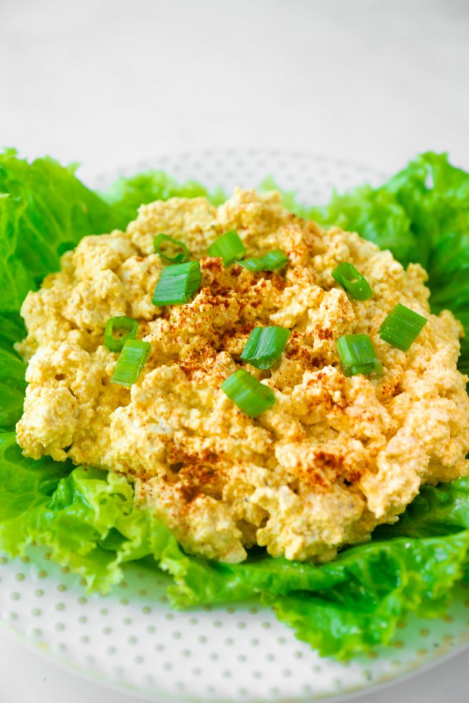 vegan egg salad on a bed of lettuce with green onions