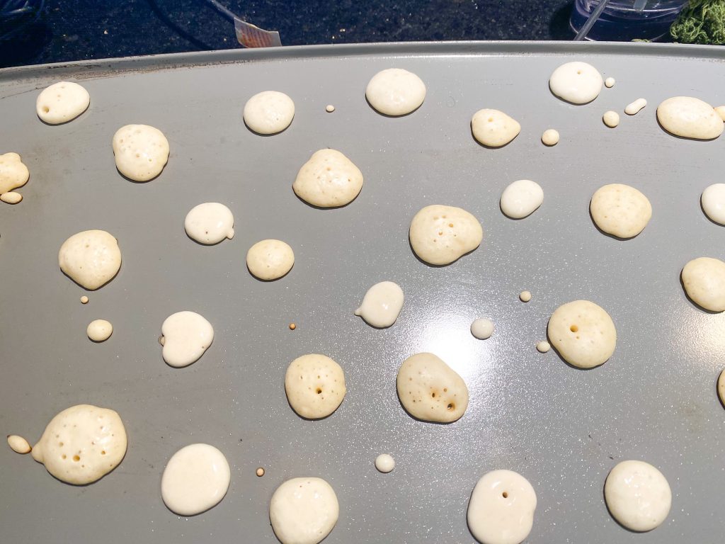 close up photo of pancake cereal cooking on griddle
