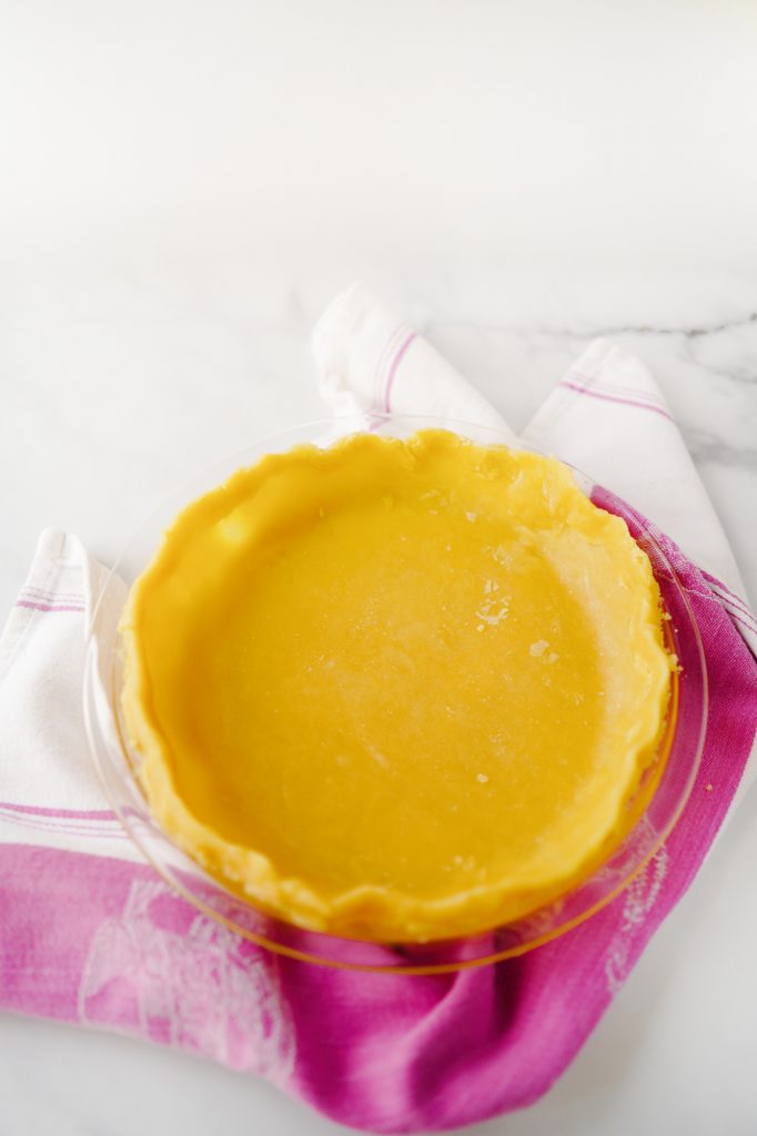 vegan pie crust in pie plate with pink towel