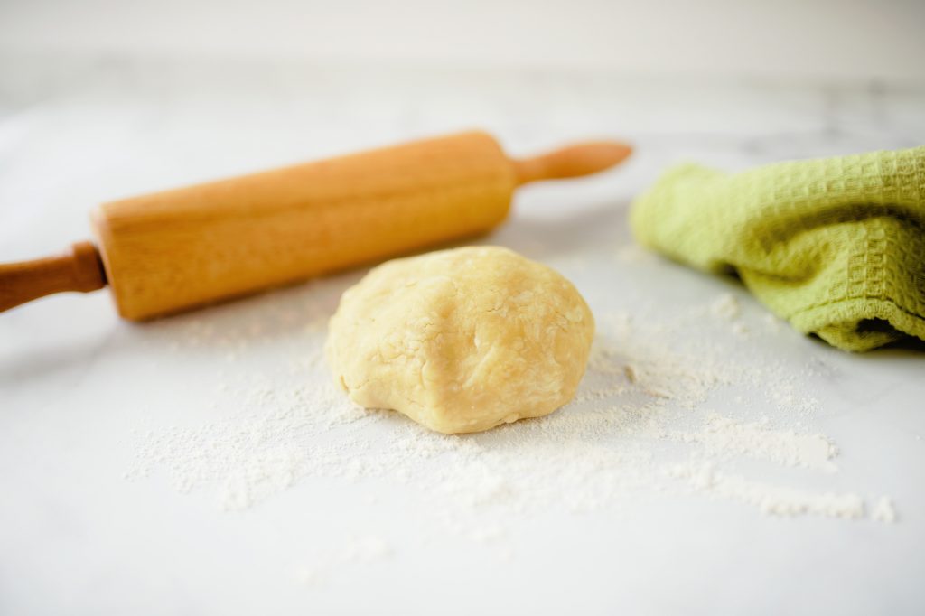 dough ball with rolling pin and green towel