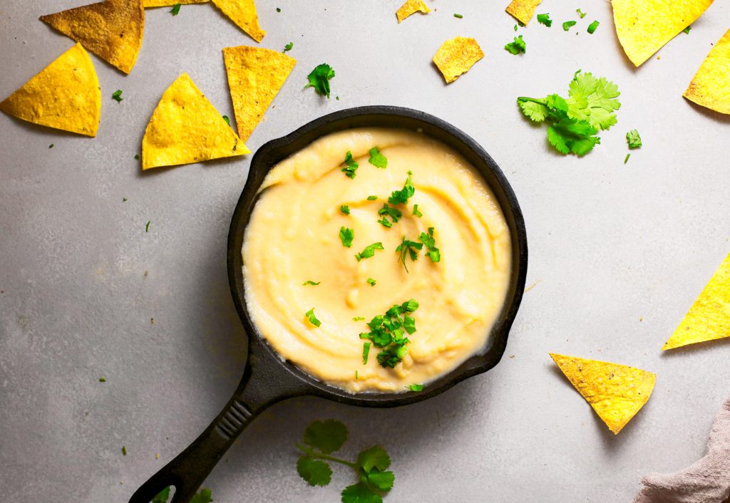 vegan queso in cast iron dish with tortilla chips