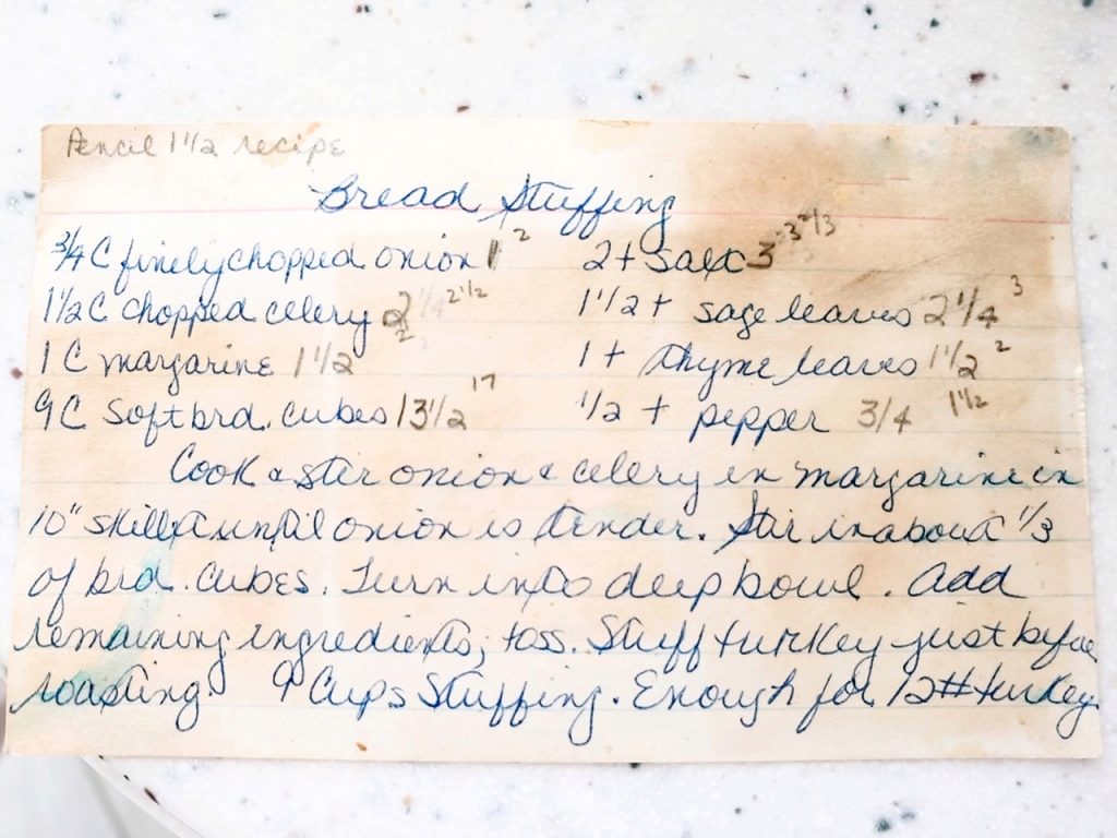 handwritten recipe for bread stuffing stained on a white counter