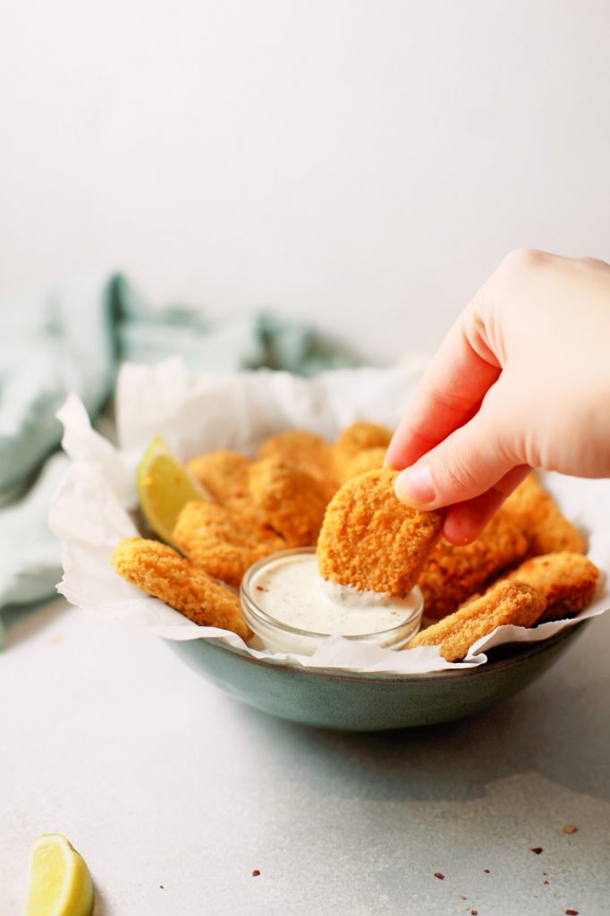 dipping a tofu nugget into vegan mayo