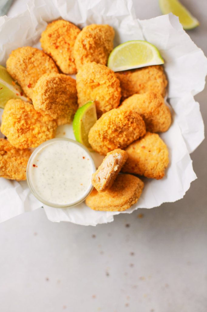 close up photo of a piece of vegan nuggets with limes