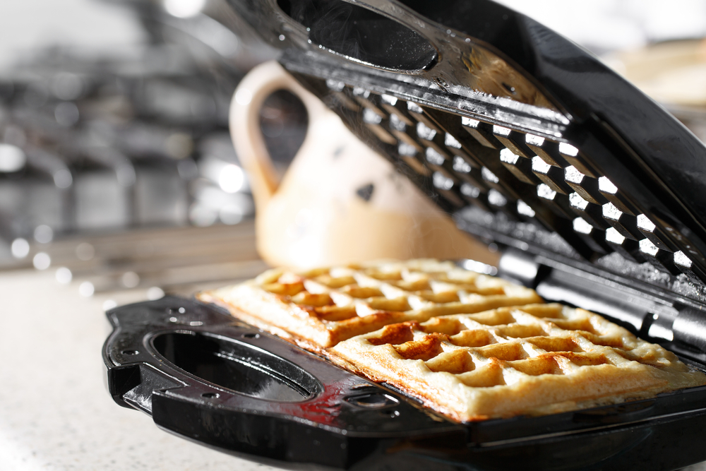 waffle iron with removable plates with vegan waffle cooking on it