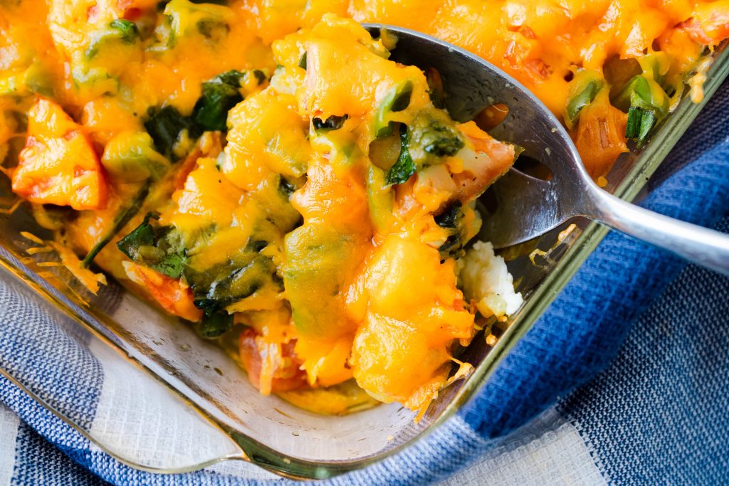 close up on spoon scooping meatless breakfast casserole with veggies