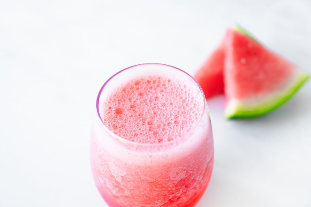 watermelon in the background of a finished watermelon smoothie