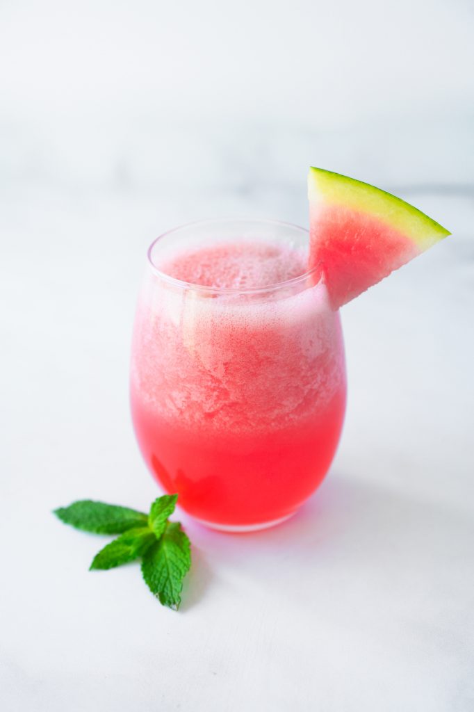 watermelon smoothie recipe on white counter with mint garnish
