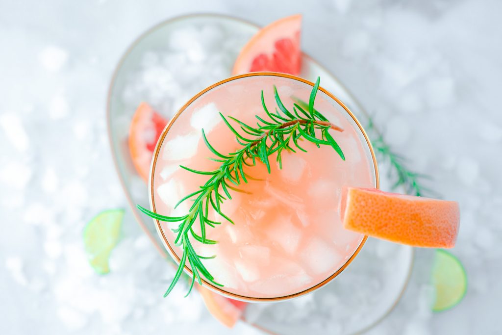 wide shot of grapefruit cocktail over ice on serving tray