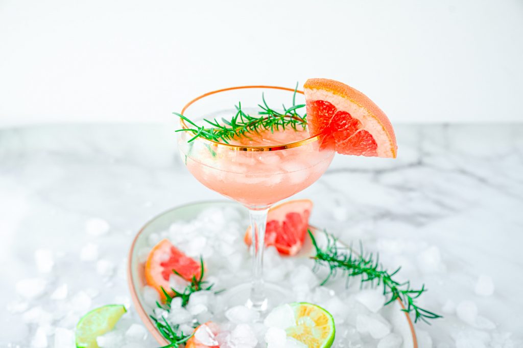 pink grapefruit juice in cocktail glass with rosemary