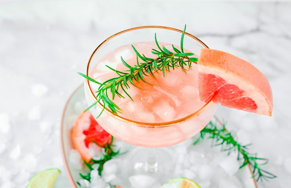 grapefruit margarita with large sprig of rosemary