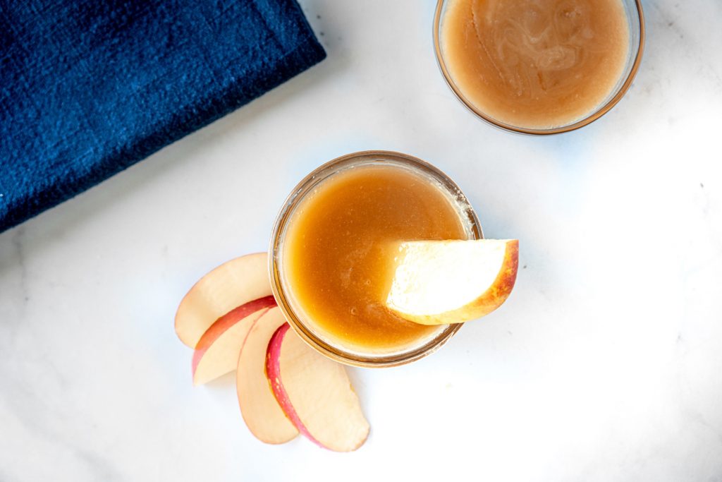 apples being dipped into vegan caramel sauce