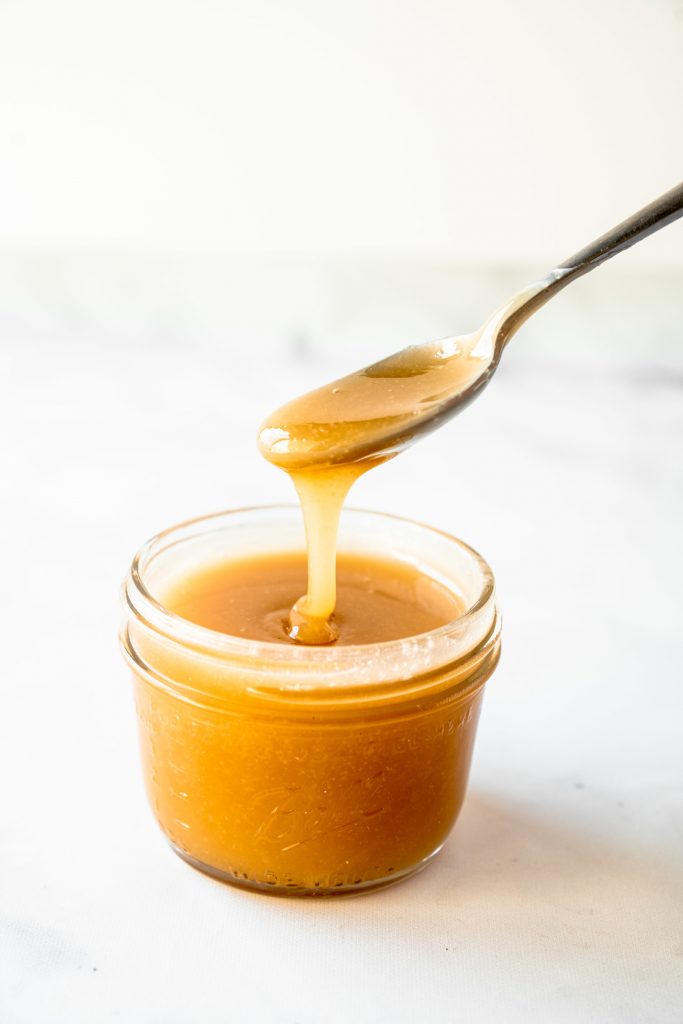 side of spoon holding vegan caramel sauce