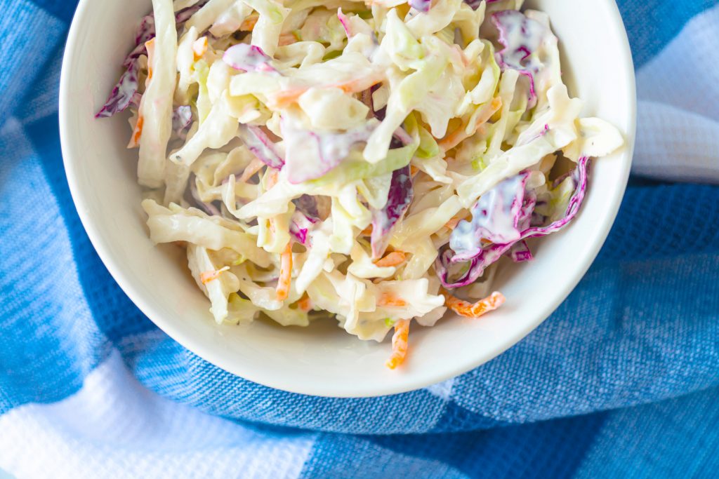 bowl of vegan coleslaw from above on a blue towel