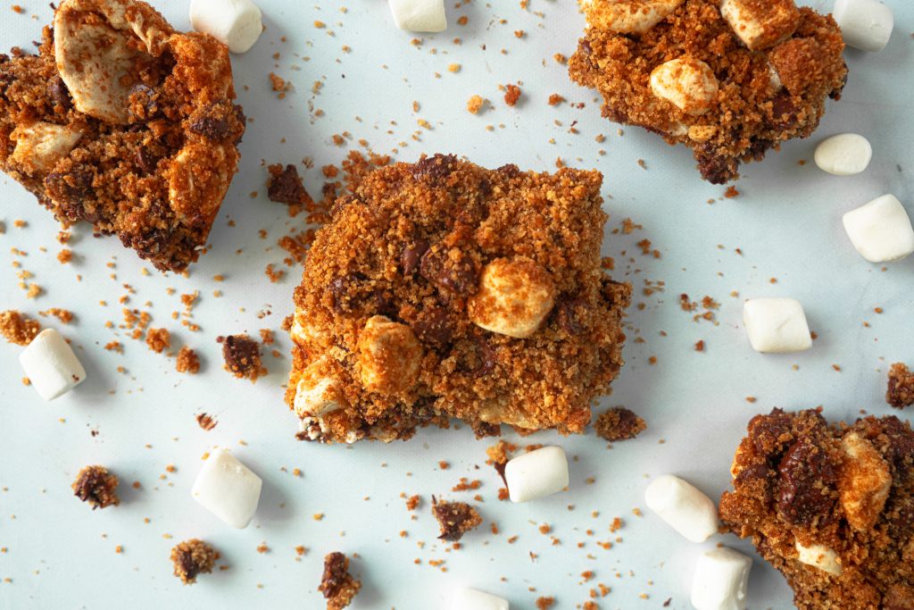 above photo of vegan smores bars on table with mini vegan marshmallows