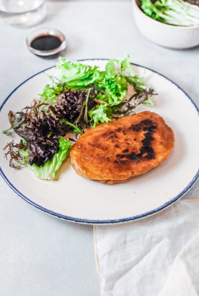 vegan steak with lettuce and sauce on plate