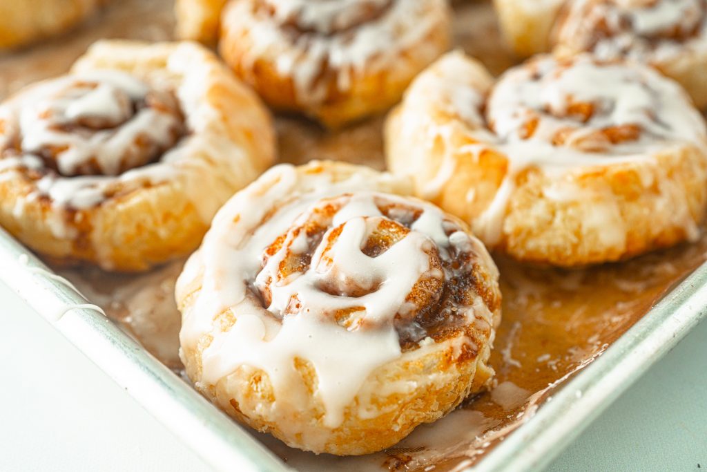 close up photo of puff pastry cinnamon rolls on baking sheet