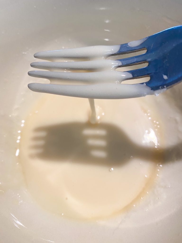 fork picking up glaze in a white bowl