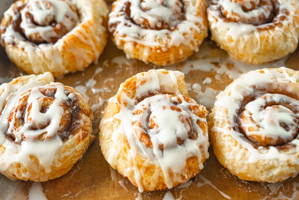 vegan cinnamon rolls on baking sheet with glaze