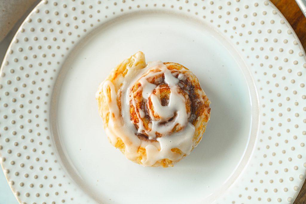 vegan cinnamon roll with glaze on plate