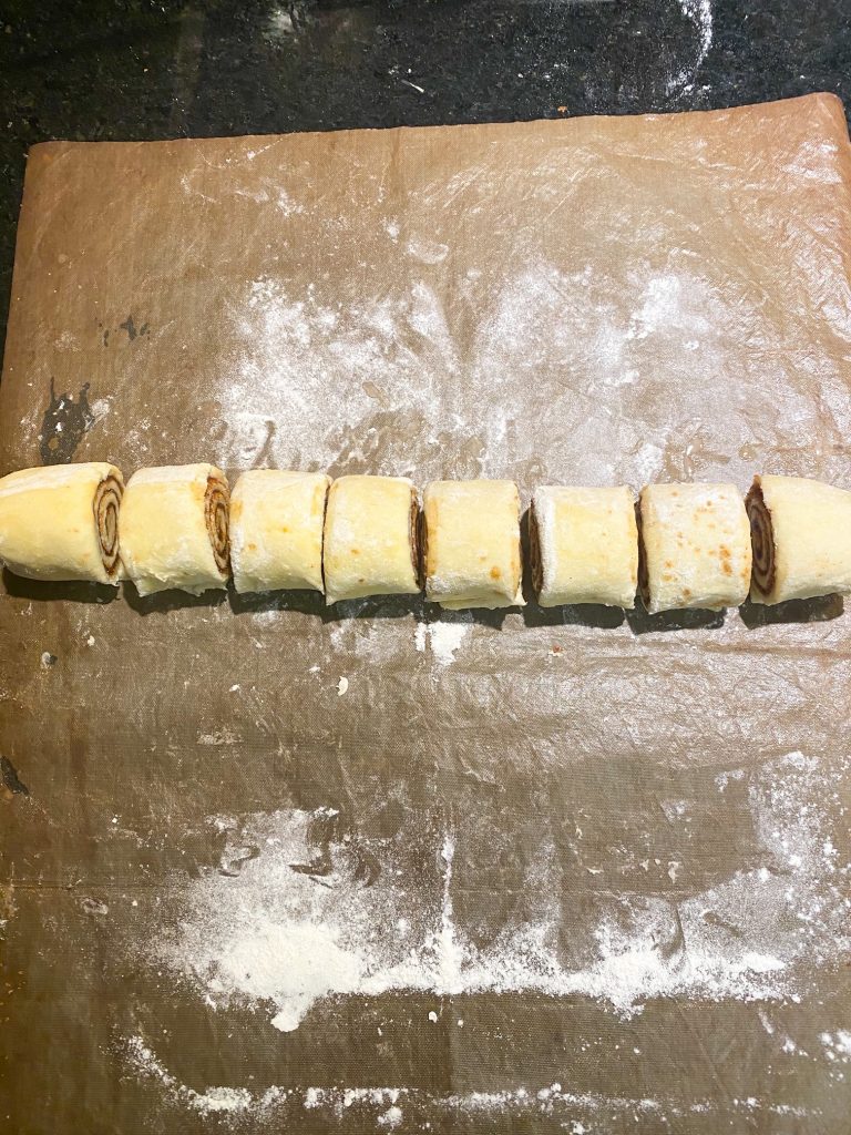 vegan cinnamon roll dough rolled up and chopped