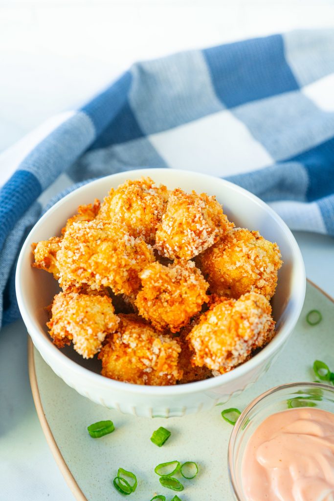 vegan crispy baked cauliflower on serving tray with dipping sauce