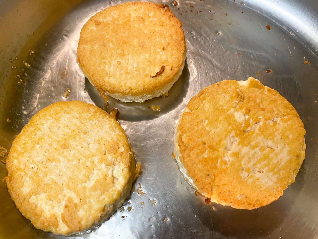 frying rounds of tofu on the stove