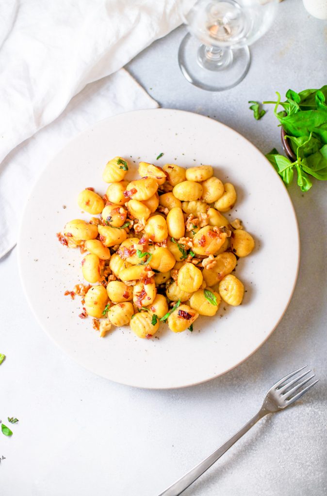 Flaylay of pumpkin gnocchi on a white plate.