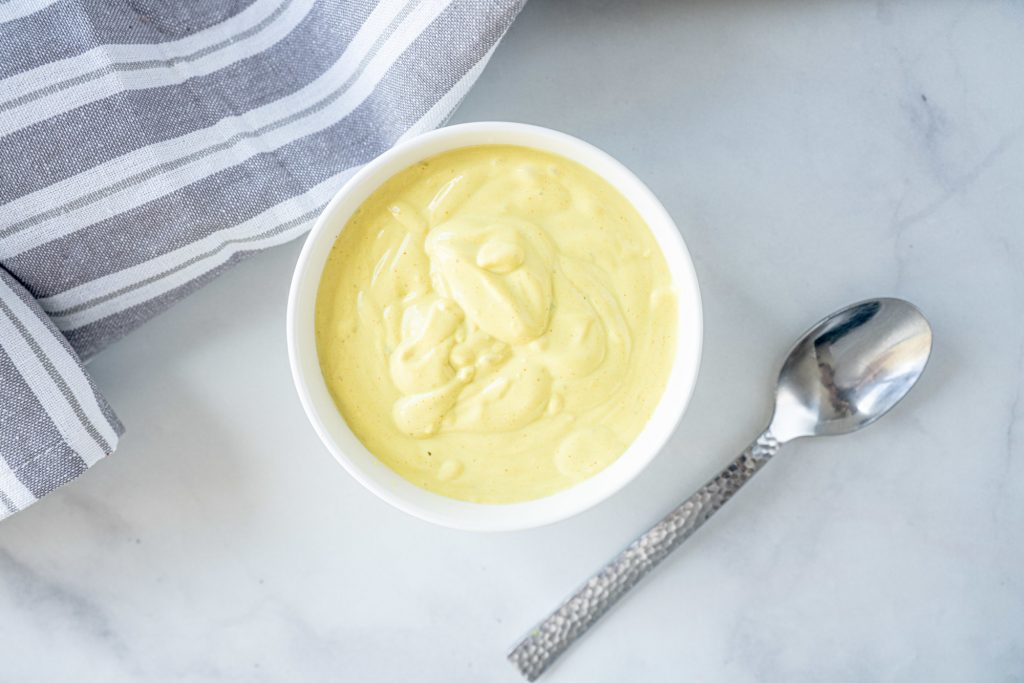 vegan hollandaise sauce in a bowl with a spoon