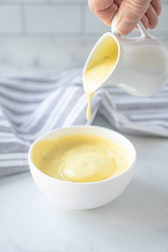 vegan hollandaise sauce being poured into a bowl