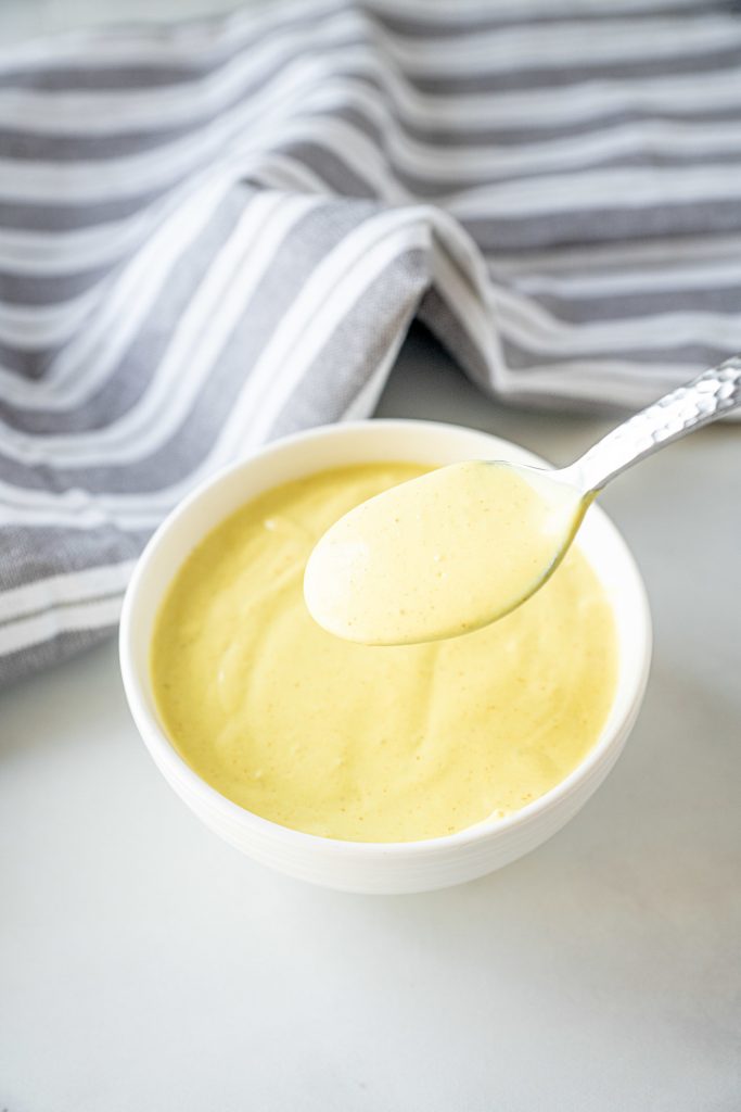 spoon picking up vegan hollandaise sauce