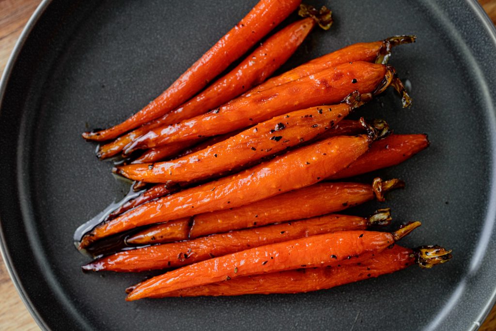 vegan maple glazed carrots on a black plate