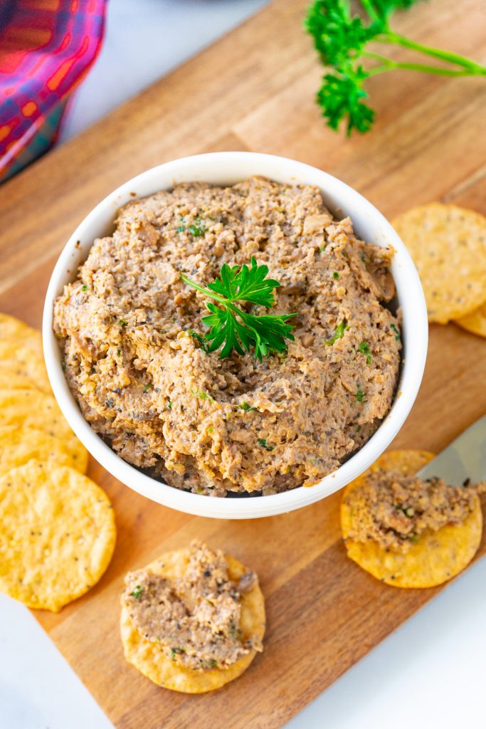 Photo of vegan pate being served in a white round bowl with crackers.