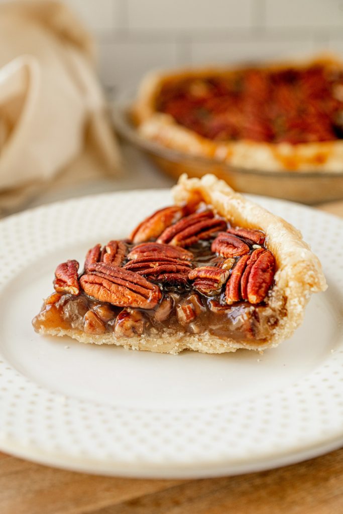 close up of eggless pecan pie recipe with filling not using corn syrup on a white plate