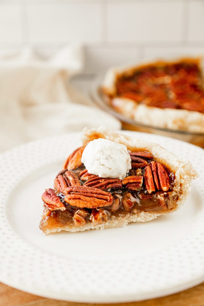 vegan pecan pie with ice cream on a white plate 