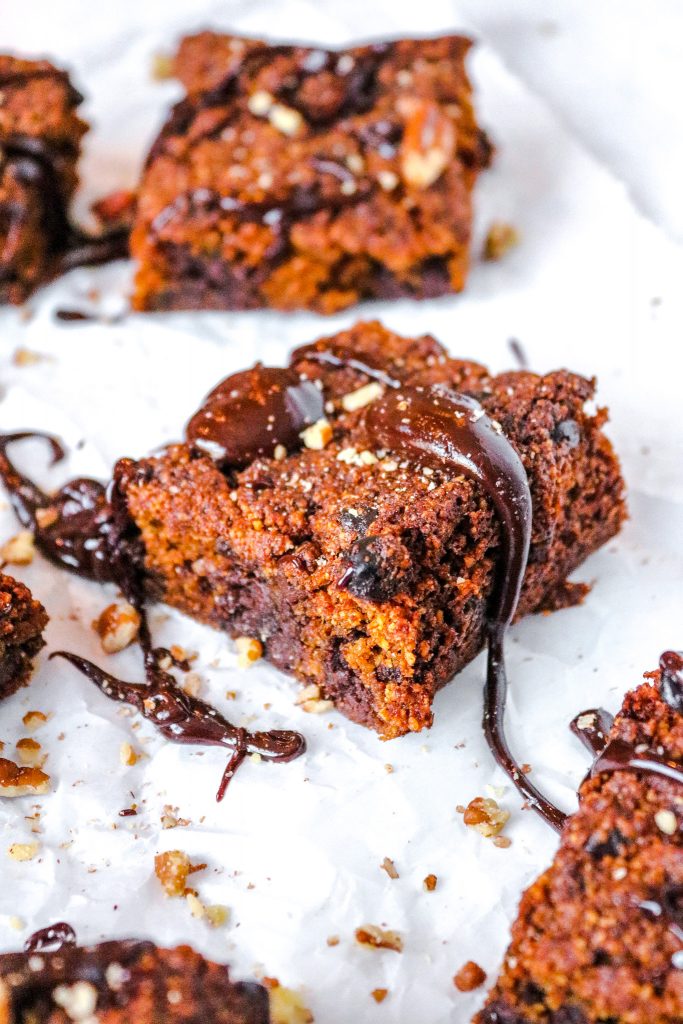 Close up of gooey vegan pumpkin brownies covered in chocolate icing, one of the best vegan fall recipes.