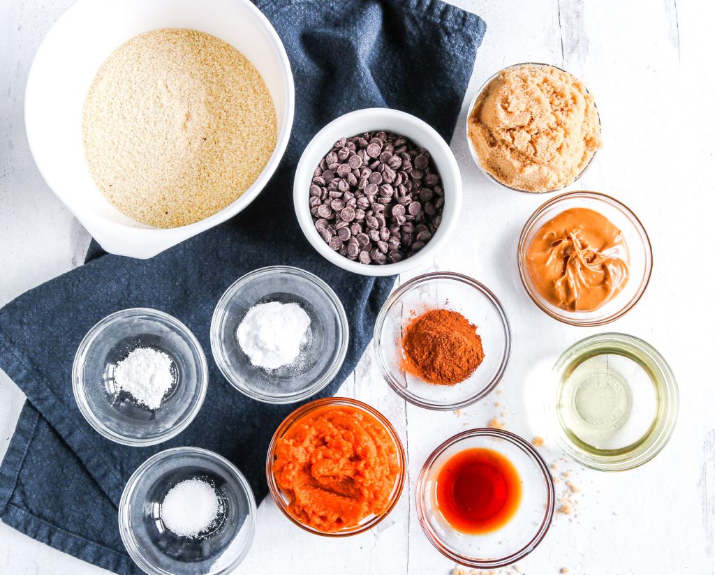 many bowls of ingredients of varying colors on a white counter top with blue towel