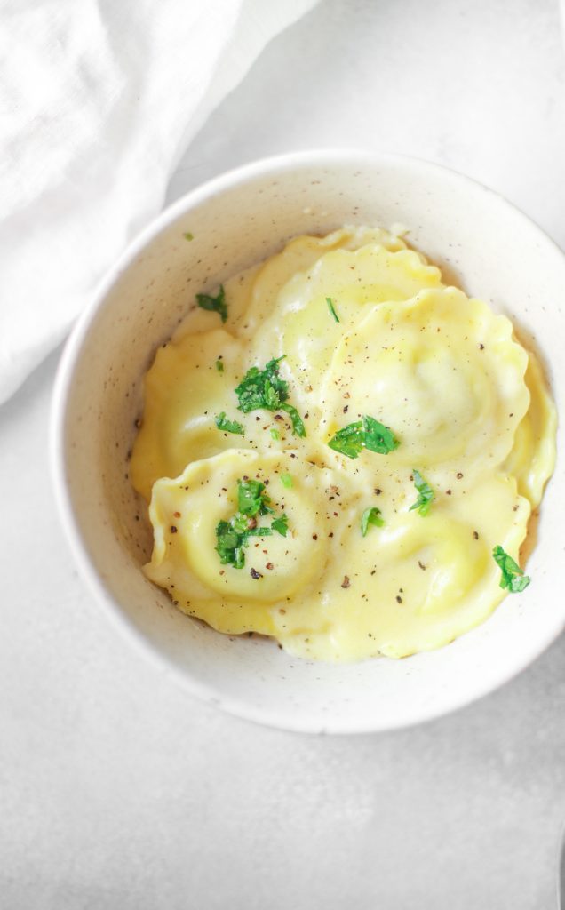 overhead shot of vegan ravioli recipe in a serving dish with green parsley on top