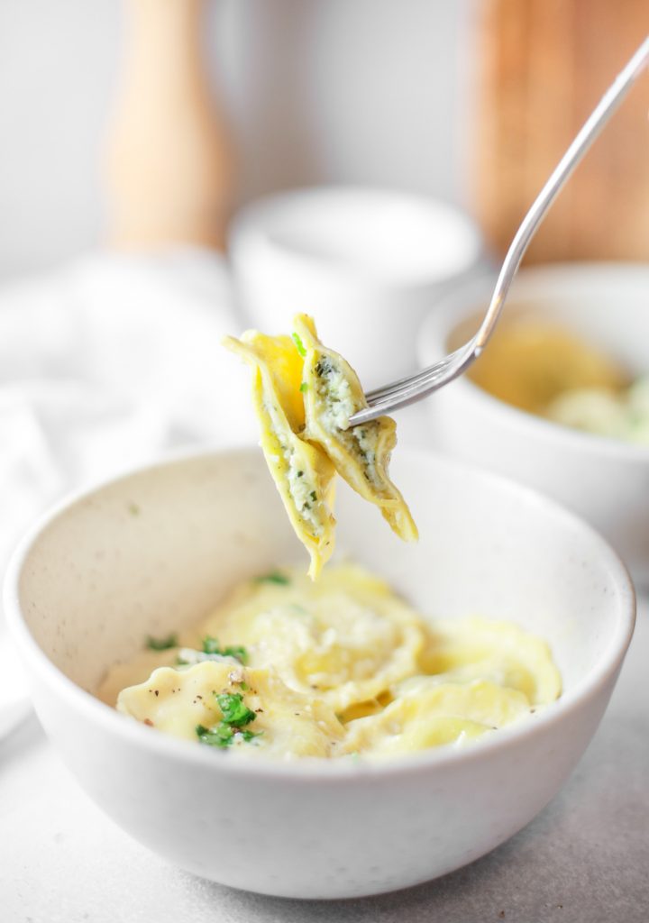 vegan ravioli on a fork with vegan ricotta filling