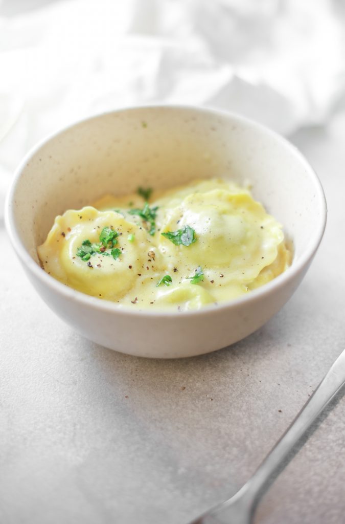 eggless vegan ravioli in a bowl that is close to the camera with seasoning