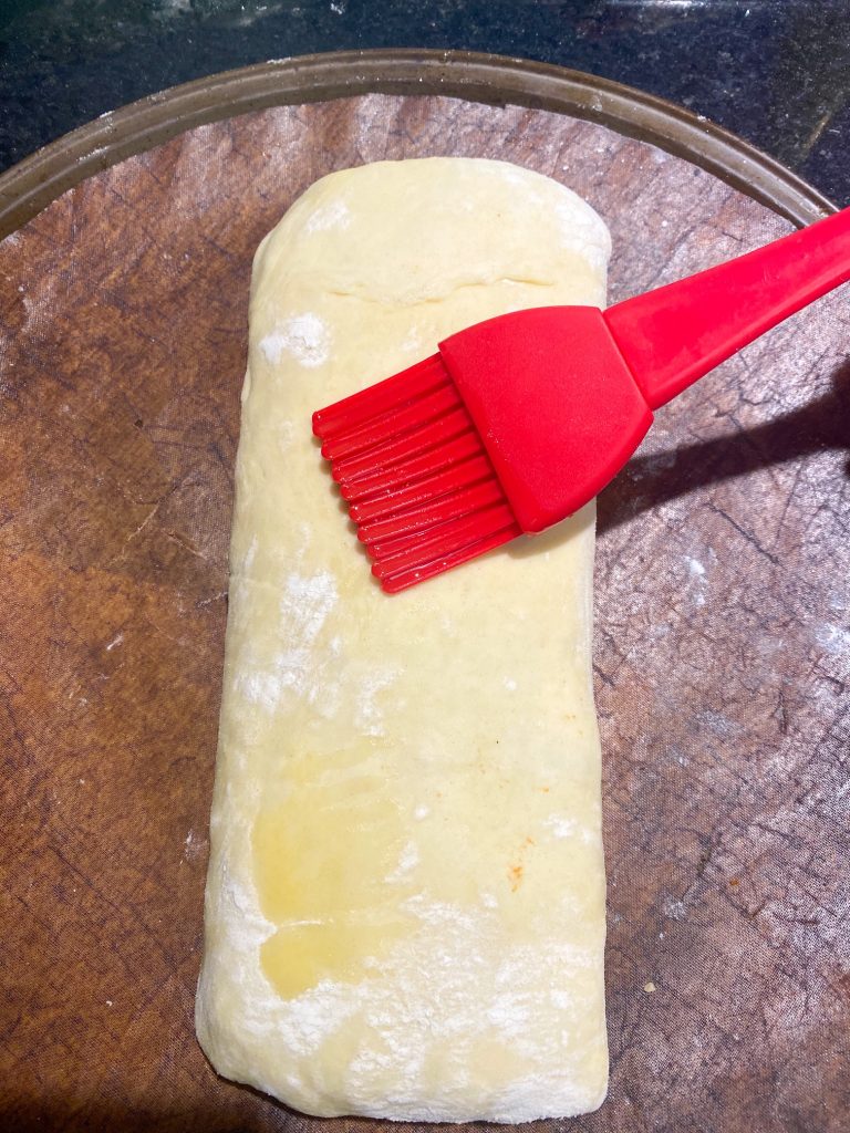 brushing vegan butter onto uncooked vegan mushroom wellington