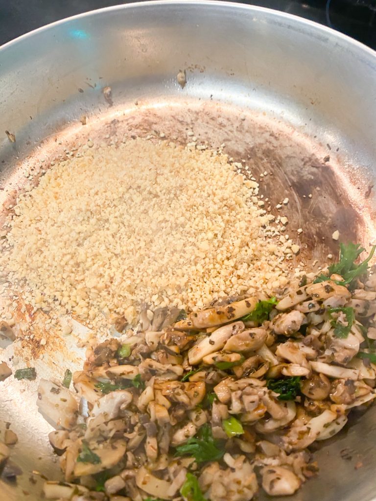 ground walnuts in a pan with saute mushrooms