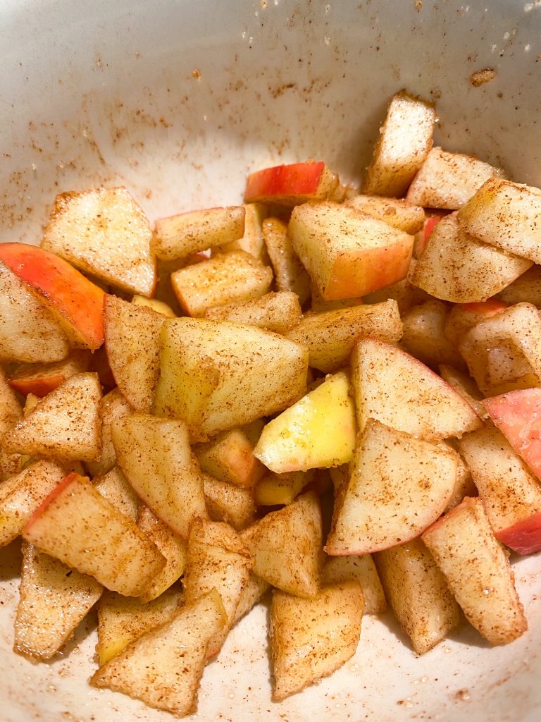 close up of spiced red apples in a dish with cinnamon on them 