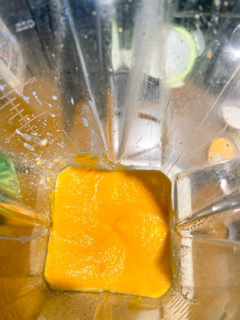inside of a blender that is yellow from butternut squash being blended
