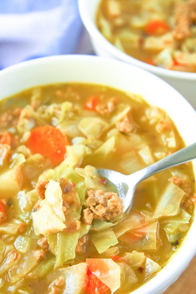 close up photo of vegan cabbage soup with spoon