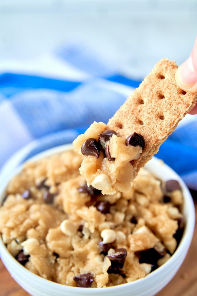 close up of hand scooping up edible vegan cookie dough with graham cracker