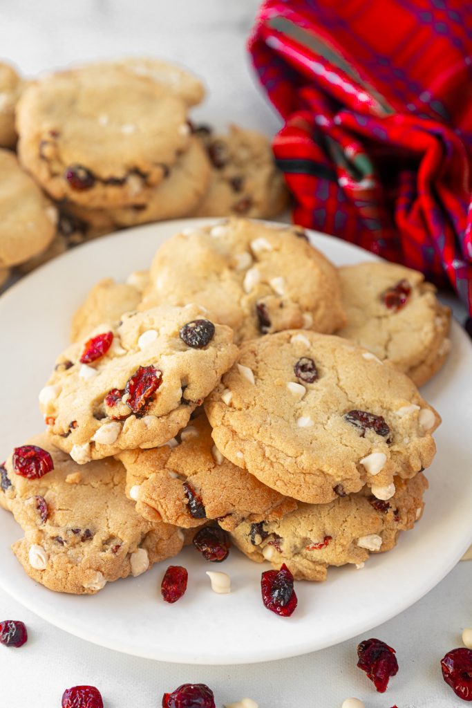 vegan cranberry cookies on plate with other cookies in background