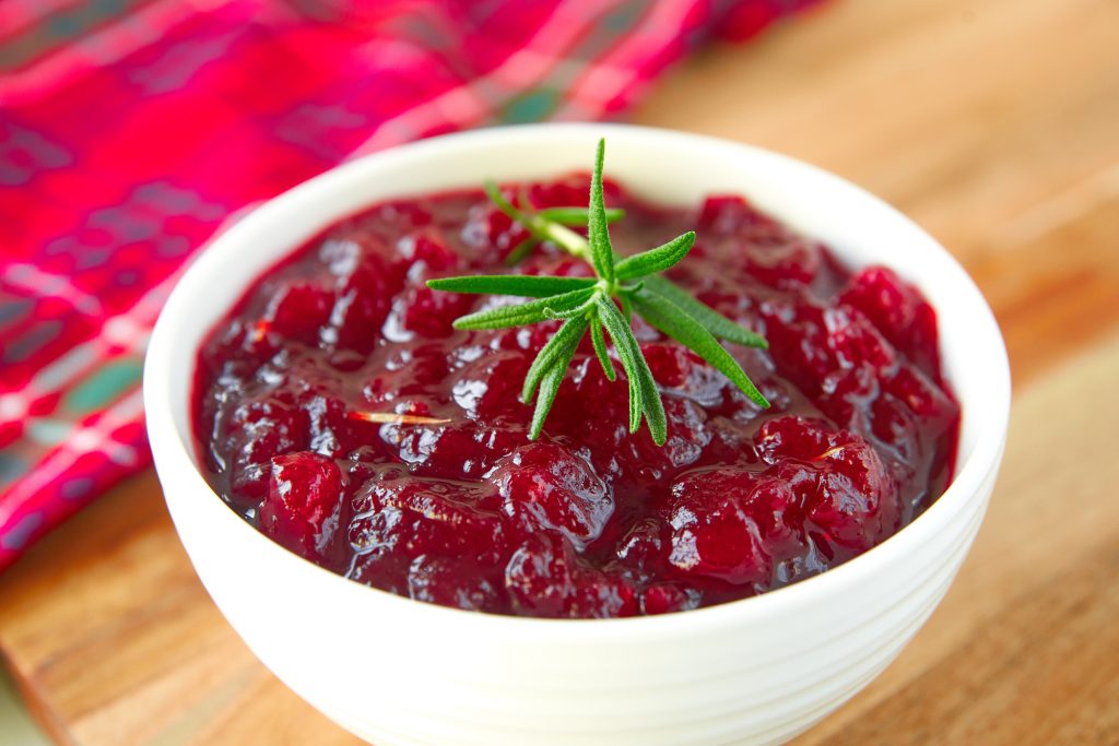 close up photo of vegan cranberry sauce that is healthy and with no added sugar or sweetener with red towel in background